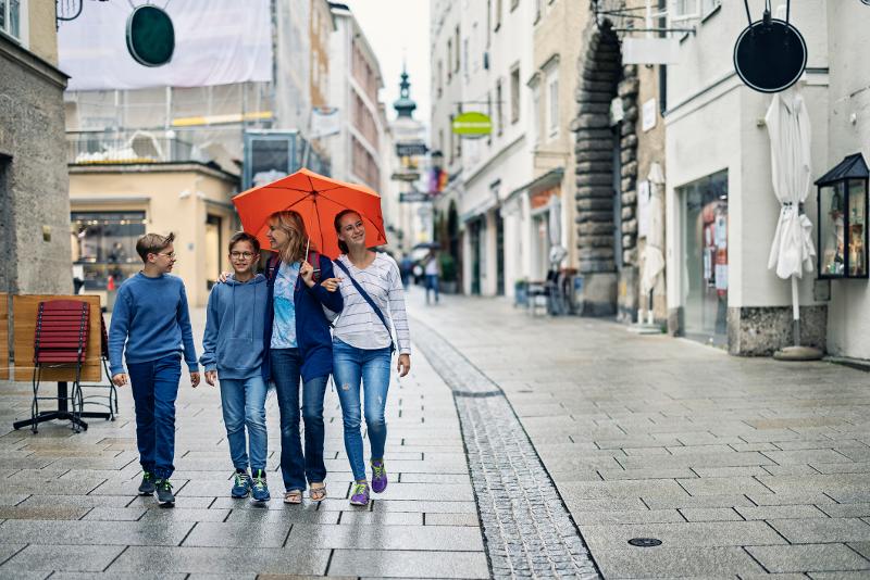  Familie läuft mit Regenschirm durch eine Gasse im Familie Kurzurlaub Deutschland