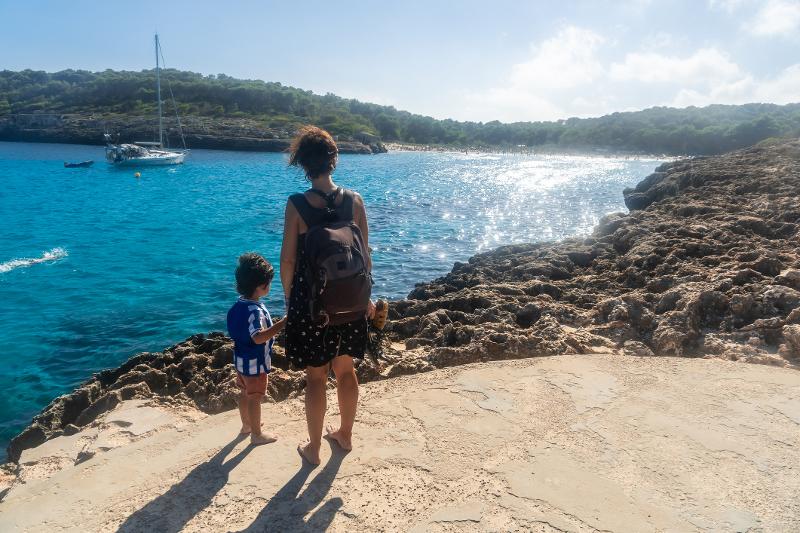 Mutter und Sohn spazieren am Meer im Kurzurlaub mit Kindern Mallorca