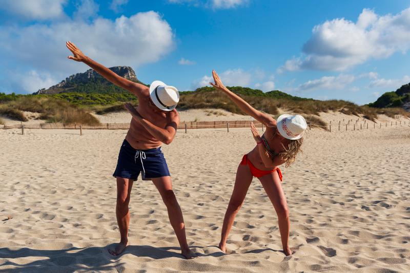 Eltern posieren im Kurzurlaub mit Kindern Mallorca am Strand