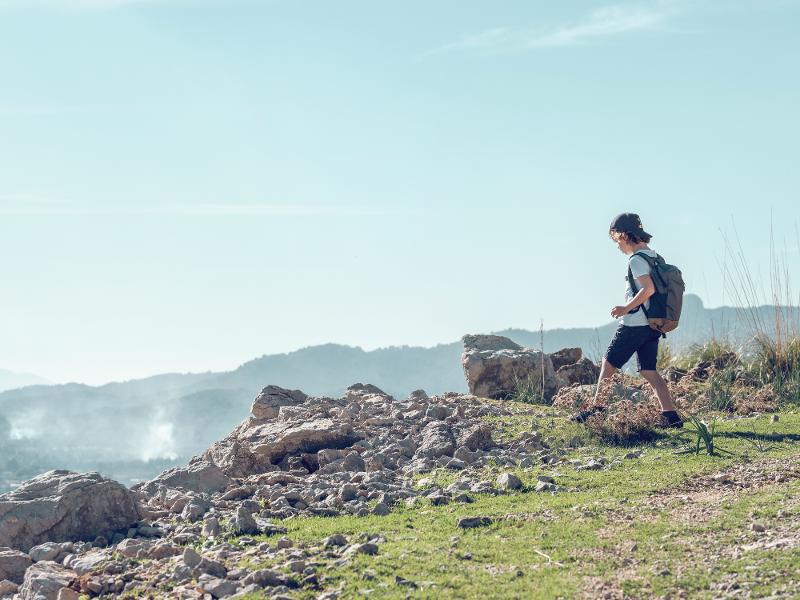 Junge läuft im Kurzurlaub mit Kindern Mallorca einen Berg hoch