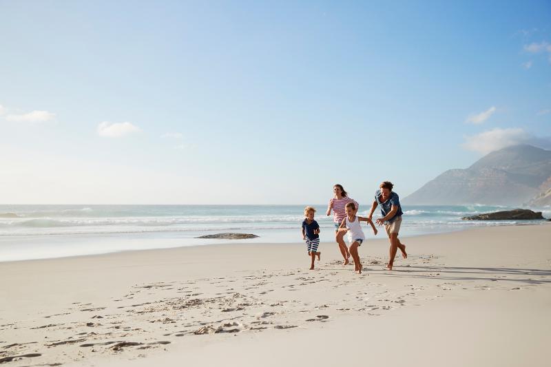 Familie rennt am Strand im Familienurlaub Luxus