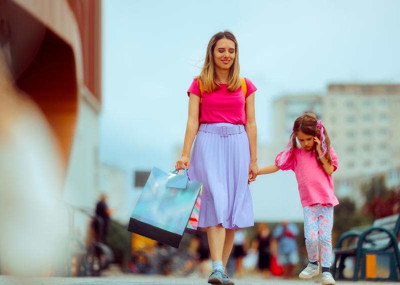 Mutter und ein Mädchen sind bei Reisen mit Kindern Mallorca in einer Stadt und kaufen ein