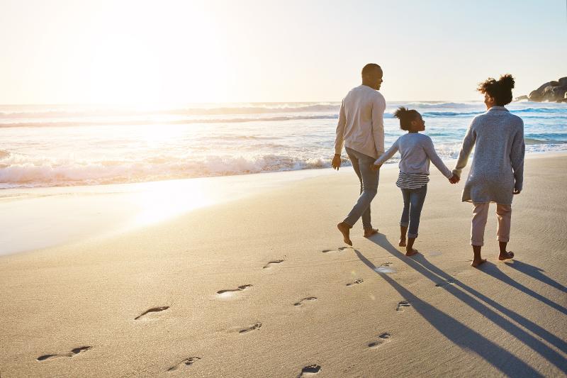 Familie am Strand im Sommerurlaub mit Kindern