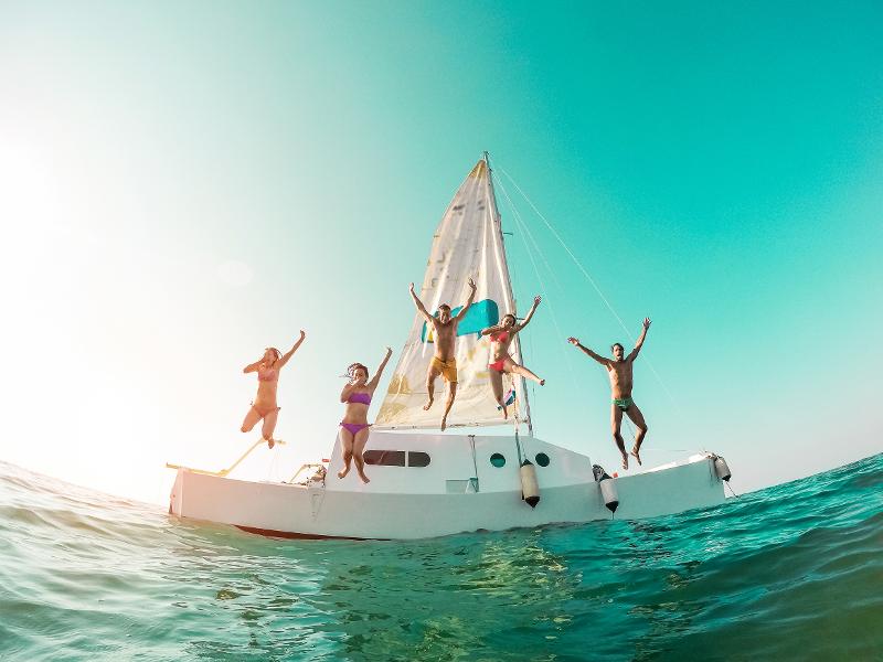 Eine Familie, die im Spanien Urlaub mit Kindern All Inclusive von einer Yacht ins Meer springt