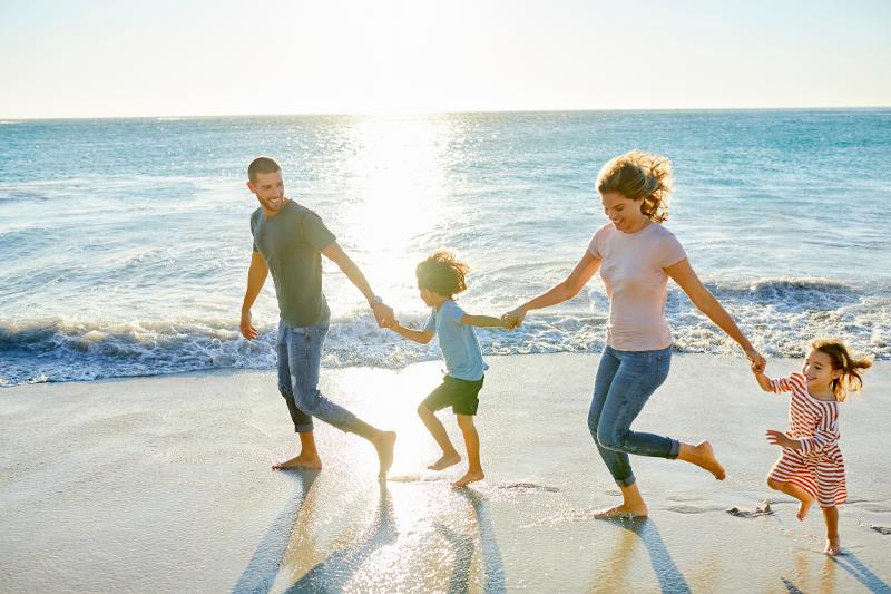 Familie läuft auf einer Familiensprachreise am Strand entlang