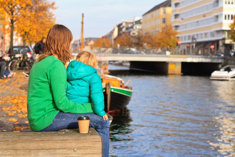  Mutter und Kind sitzen im Herbst am Wasser in Kopenhagen beim Städtetrip mit Kindern