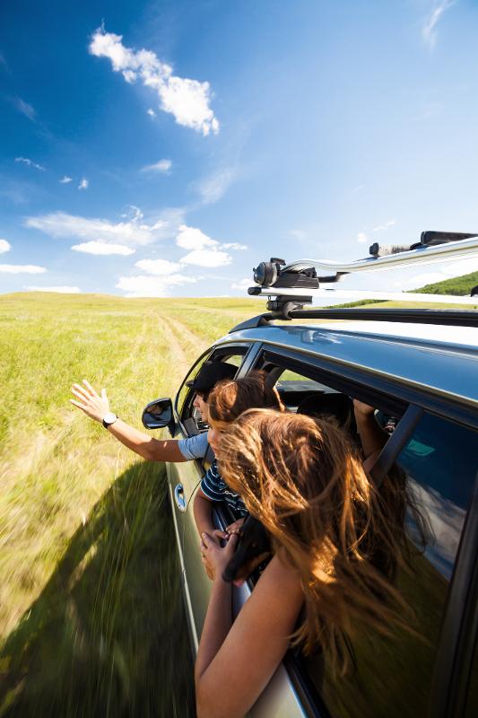 Familie fährt zusammen Auto in den Urlaub günstig mit Kindern in Deutschland und schaut aus den Fenstern
