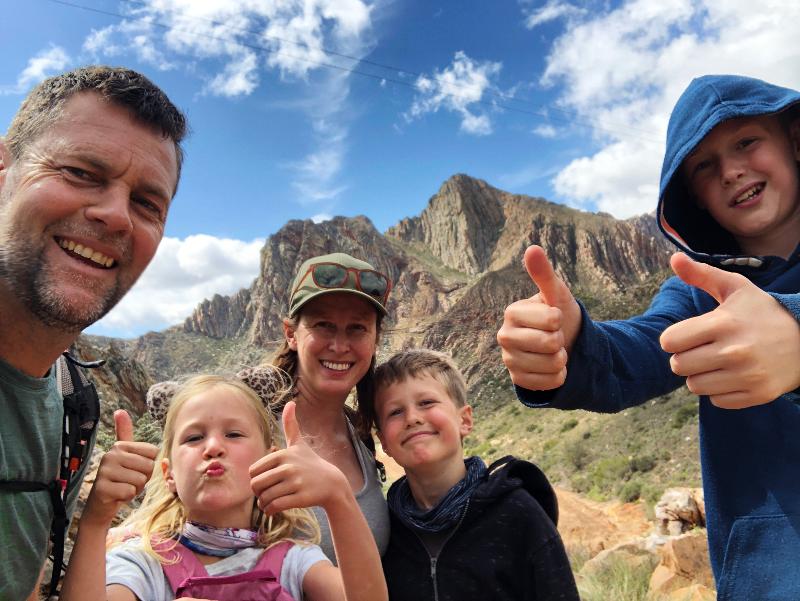 Mutter, Vater und drei Kinder machen im Urlaub günstig mit Kindern in Deutschland ein Selfie vor einem Berg