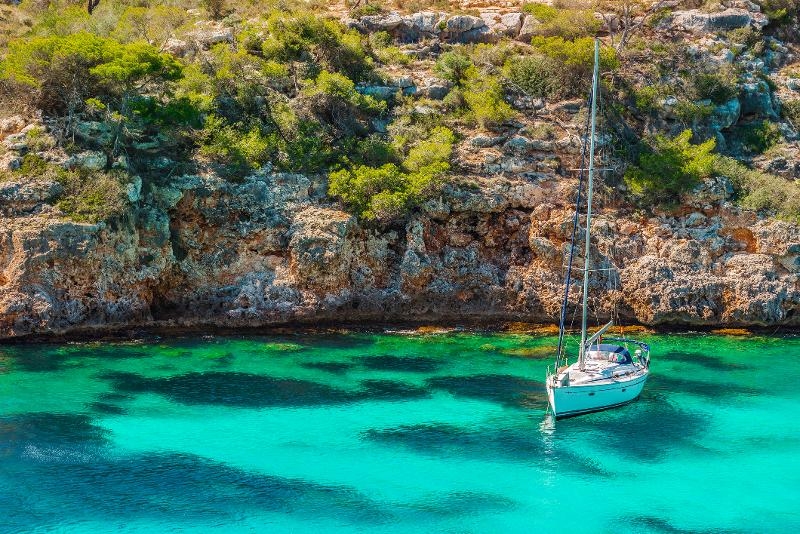 Yacht steht in einer ruhigen Bucht im Urlaub mit Kindern Menorca