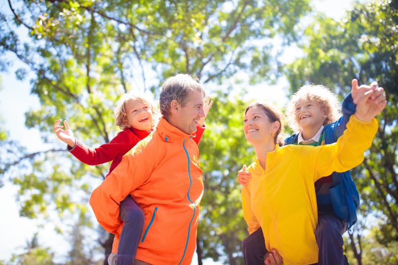 Mutter, Vater und zwei Kindern haben gemeinsam Spaß und lachen sich an