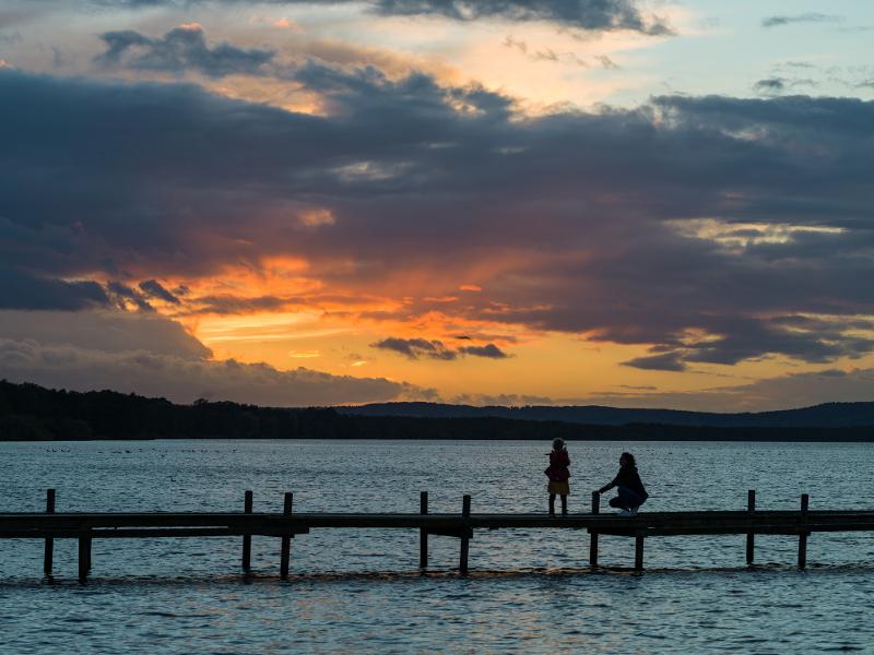 Steg im Meer mit Sonnenuntergang im Hintergrund im Urlaub mit Kindern in Deutschland
