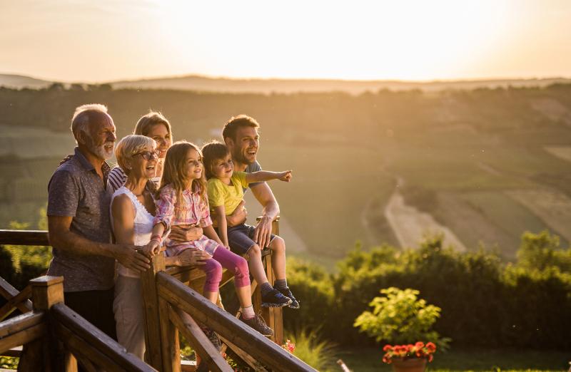Familie steht beim Sonnenuntergang auf einer Aussichtsplattform