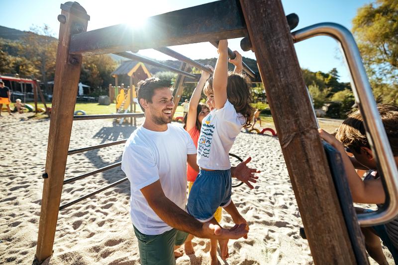 Vater und Kind spielen zusammen auf einem Spielplatz