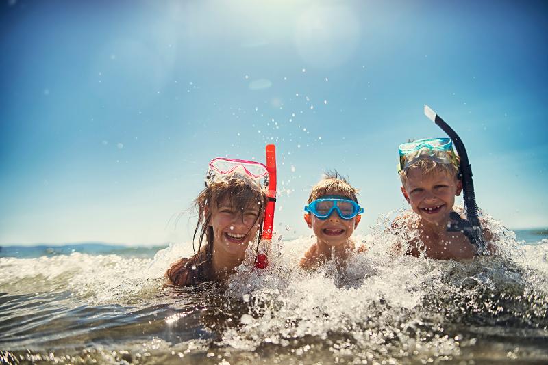  Drei Kinder spielen im Meer im Urlaub mit Kindern in Italien am Meer günstig
