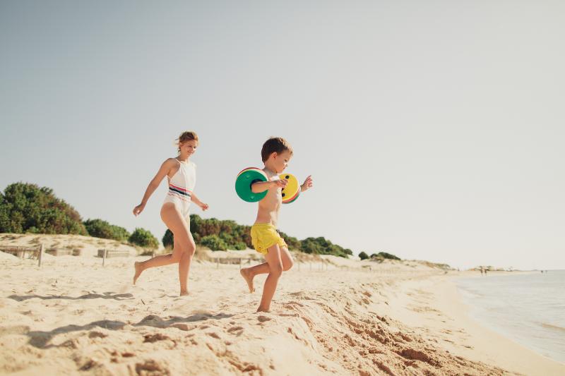  Eine Mutter mit Kind hat Spaß am Strand im Italien Urlaub mit Kindern am Meer