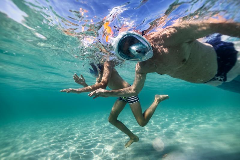 Ein Erwachsener und ein Kind unter Wasser im Urlaub mit Kindern Italien am Strand