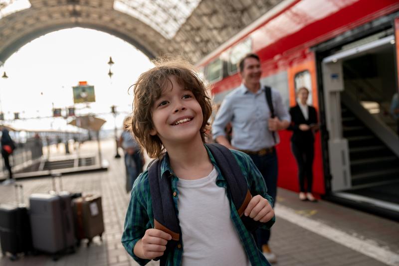 Kleiner Junge mit Gepäck am Bahnhof beim Urlaub mit Kindern