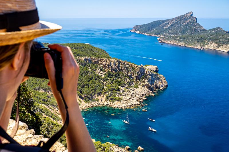 Vater fotografiert im Urlaub mit Kindern Mallorca Hotel und genießt die Aussicht