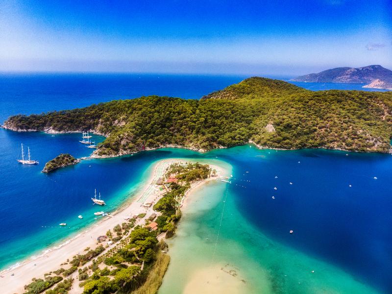Aussicht auf eine Bucht mit Meer, Strand, Booten und Bäumen im Urlaub mit Kindern Türkei