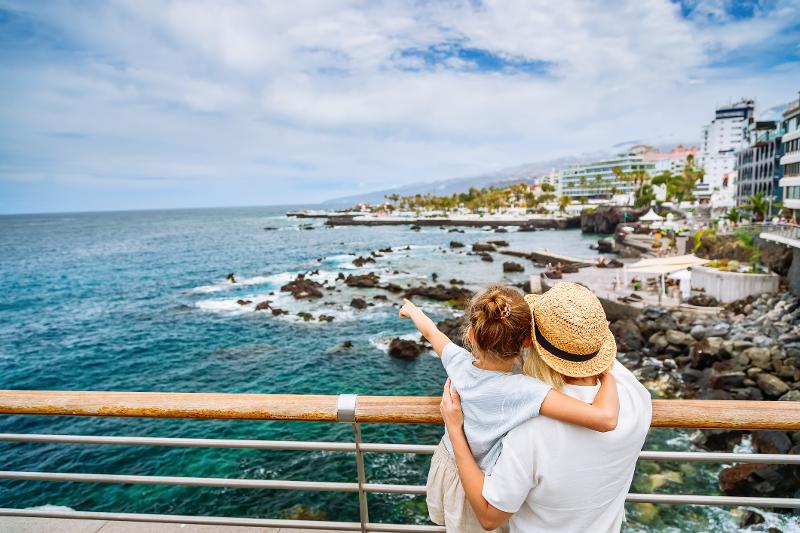Ein Vater und sein Kind gucken sich die Aussicht vom Meer und der Bucht im Urlaub mit Kindern Zypern an