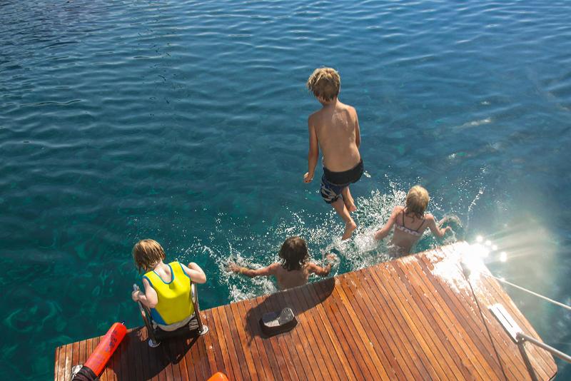 Kinder springen vom Steg bei ihrer Familien-Segelreise
