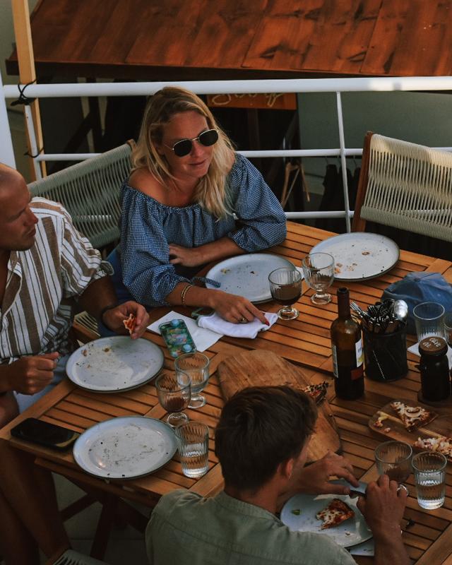 Mutter und Vater am Esstisch auf der Terrasse im Familienurlaub Surfen