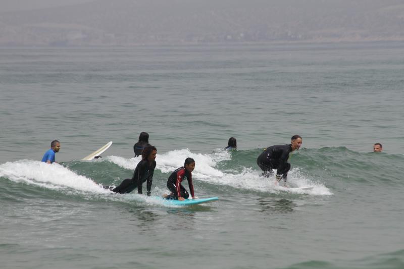 Kind surft mit Surfcoaches