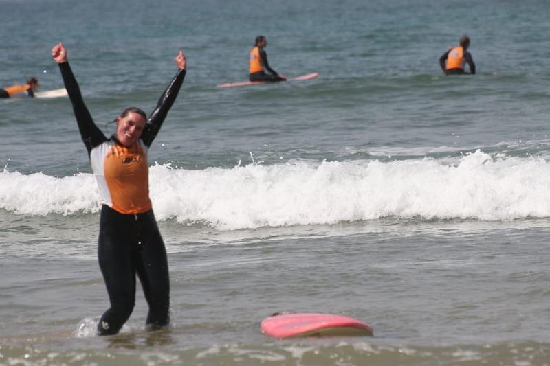 Surferin freut sich das sie die welle geschafft hat, am strand, surfer, familienurlaub marokko