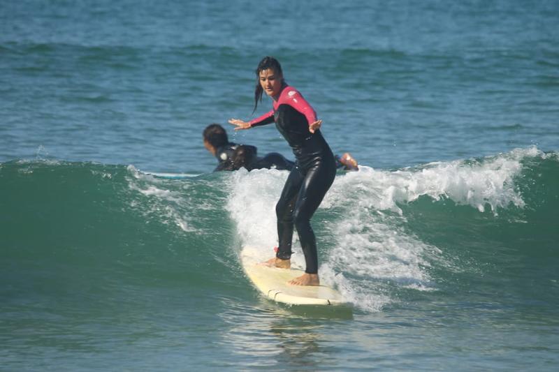 Surferin reitet die welle an der Atlantikküste 