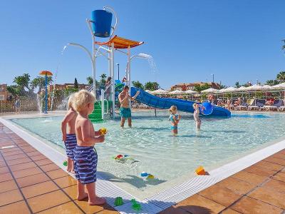 Kinder im Kinderbadebereich mit blauer Rutsche und Splashpool im Familienurlaub Mallorca