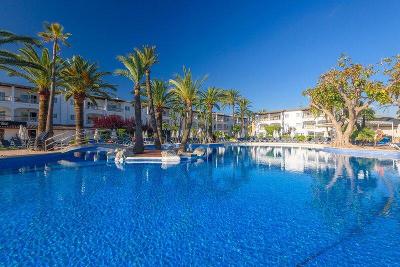 Großer Pool mit Palmen und Brücke im Familienurlaub Mallorca