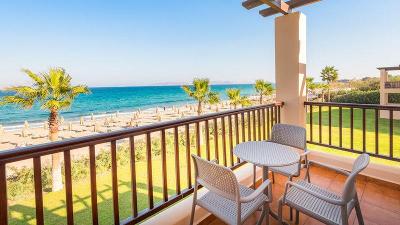 Blick vom Balkon auf Wiese und Strand mit Sonnenliegen im Familienurlaub Kos