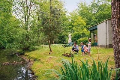 Familie füttert Enten vor ihrem Ferienhaus im Familienurlaub Niederlande