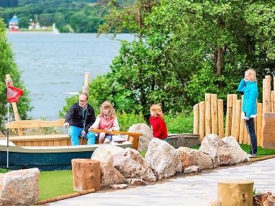 Vater und Kinder beim Minigolf im Familienurlaub Deutschland