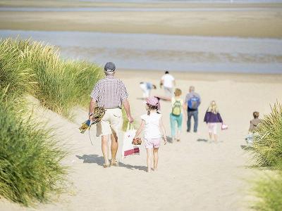 Mehrgenerationen auf dem Weg zum Strand im Familienurlaub Belgien