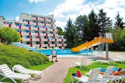 Mehrstöckiges Hotelgebäude mit Pool und gelber Wasserrutsche im Familienurlaub Deutschland