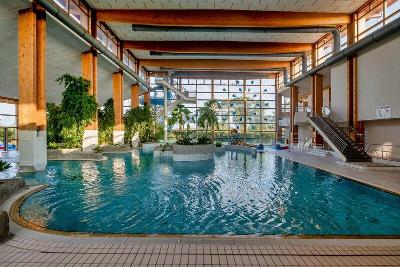 Hallenbad mit Grünpflanzen und großer Glasfront im Familienurlaub Ostsee