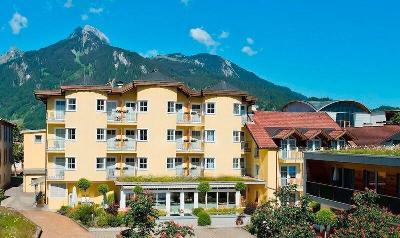 Gelbes Hotelgebäude vor den Bergen im Familienurlaub Österreich