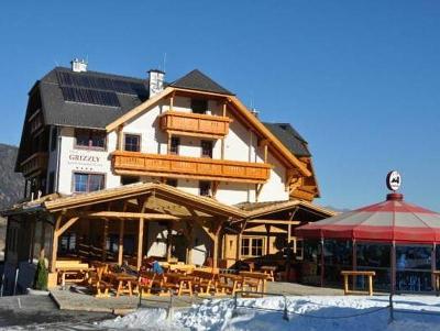 Hotelgebäude mit Holzbalkonen und Terrasse im Familienurlaub Österreich