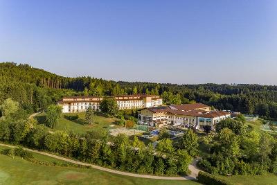 Zwei Hotelgebäude umgeben von Wäldern im Familienurlaub Österreich