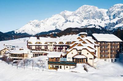 Verschneites Hotel in schneebedeckten Bergen im Familienurlaub Österreich