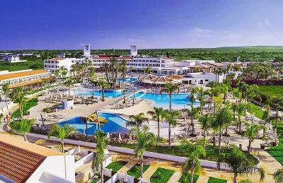 Weitläufige Hotelanlage mit mehreren Pools, Kinderrutschen und viel Grün im Familienurlaub Zypern