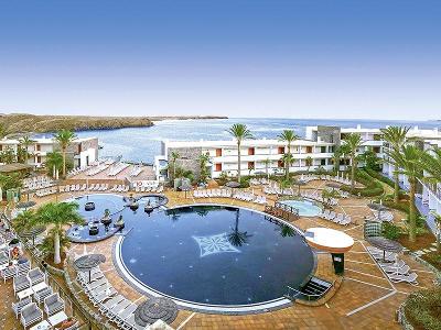 Runder Pool mit Sonnenliegen direkt am Meer im Familienurlaub Lanzarote