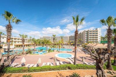 Mehrstöckiges Hotel mit großer Poolanlage, Palmen und Liegen im Familienurlaub Portugal