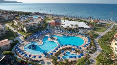 Pool mit blauen Sonnenschirmen direkt am Meer im Familienurlaub Griechenland