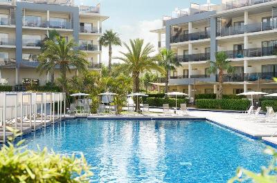 Klassischer Pool mit Daybeds und Palmen im Familienurlaub Spanien
