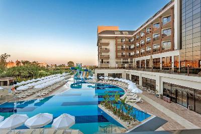 Liegen mit Schirmen am Pool und Hotelgebäude im Familienurlaub Türkei