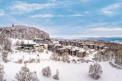 Verschneite Berge mit Hotelanlage im Winterurlaub Deutschland