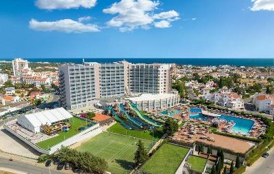 Mehrstöckiges Hotelgebäude mit mehreren Wasserrutschen und Sportplatz im Familienurlaub Portugal