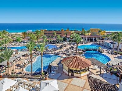 Mehere Pools mit Brücke, Terrasse und Palmen im Familienurlaub Fuerteventura